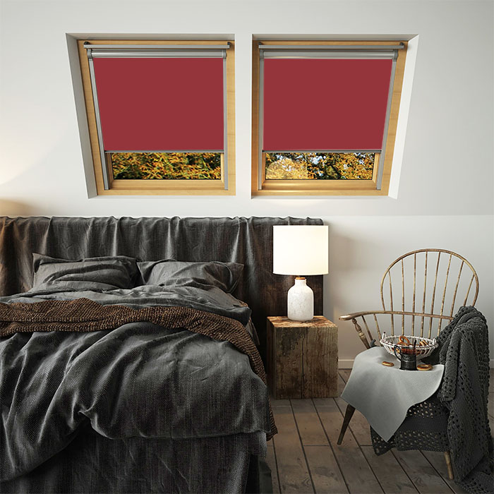 A pair of deep red skylight blinds for velux windows in a bedroom